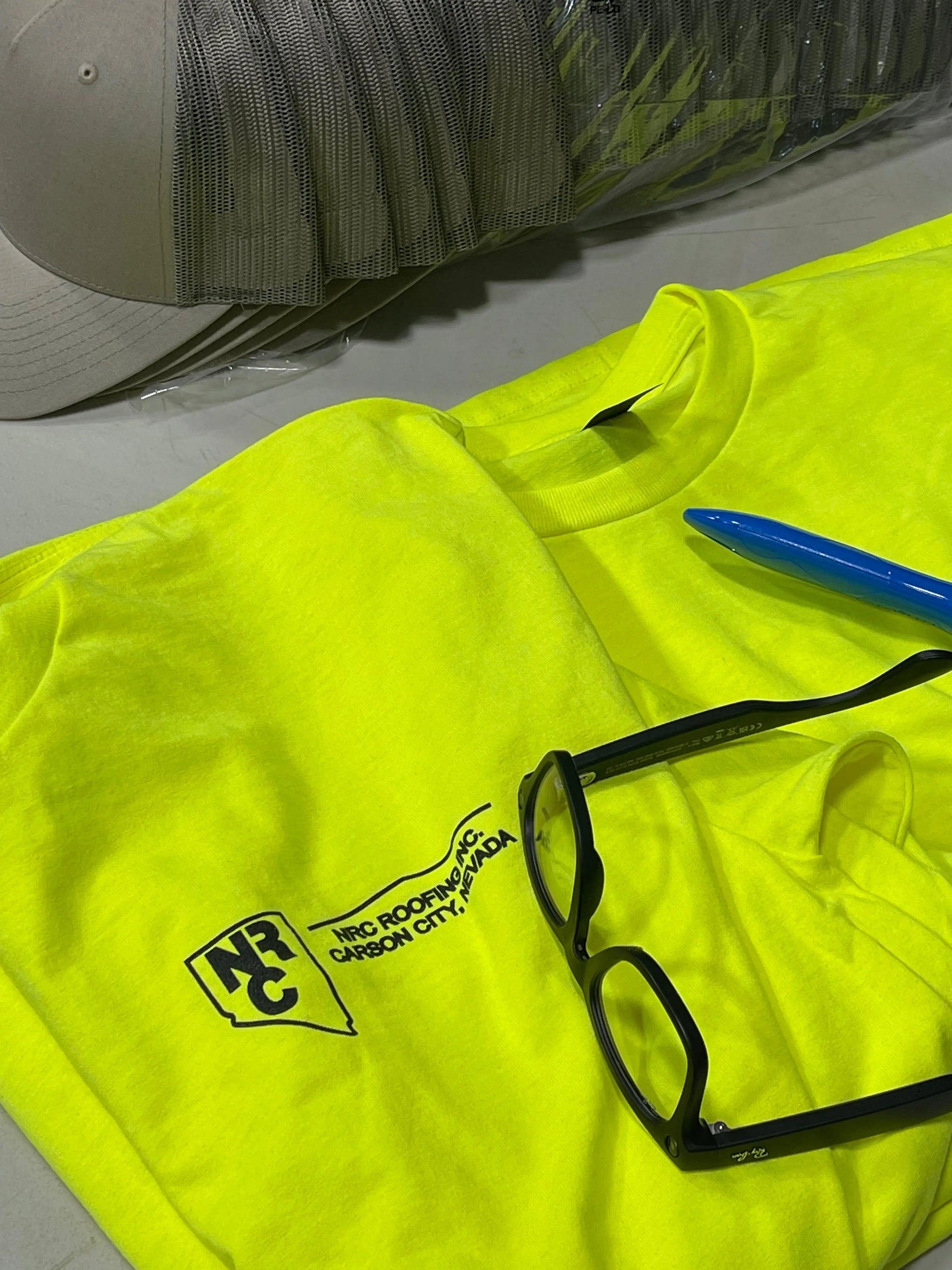 Custom printed hi-viz safety t-shirt with black company logo for a roofing contractor, produced in-house by Game Over Merch for blue collar workwear.